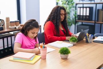 Mother and daughter working at office