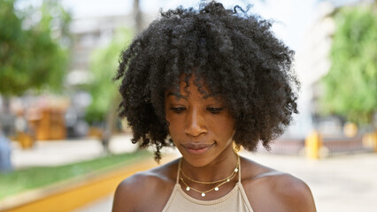 African american woman looking down with serious expression at park © Krakenimages.com