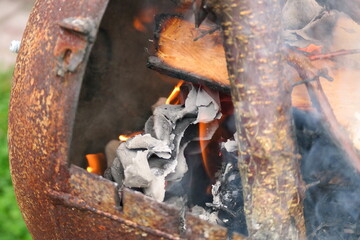 burning wood and paper. firewood is burning. tongues of flame. orange flame. bonfire. wood-fired cooking. firewood is burning for cooking barbecue