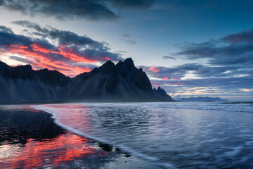 Vestrahorn mountain and dramatic sky over black sand beach in summer at Iceland
