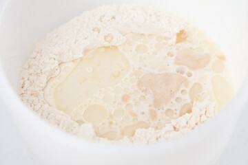 Adding leavened yeast. Home made pizza dough preparation. Pizza preparation.