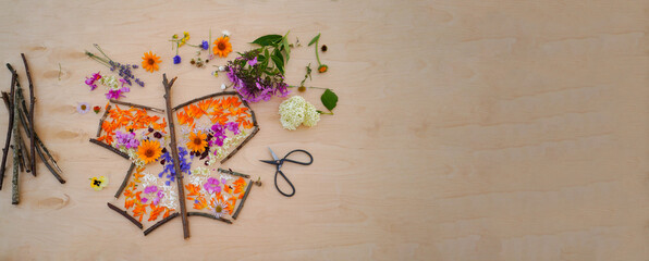 Banner with butterfly made from flowers, easy nature craft for kids. Making fairy landscape, inspiration, imagination, sensory perception. easy nature craft for kids