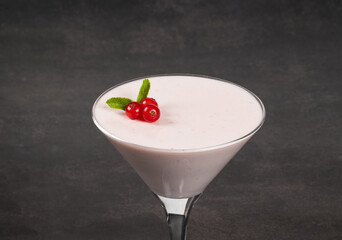 Red currant cream Panna Cotta, in a martini glass. Dark background. Close up