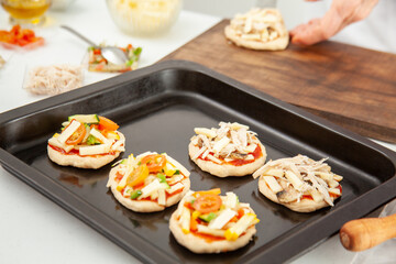 Ready to be baked mini pizzas. Delicious home made mini pizzas preparation.