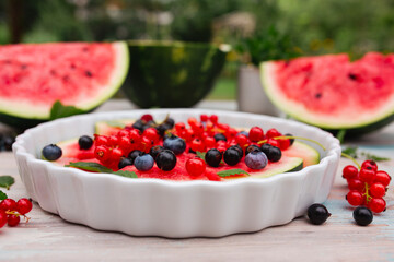 Fruity watermelon pizza with seasonal fruits on the garden table
