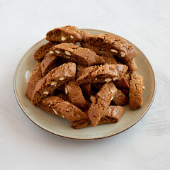 Homemade Italian Cantuccini with Almond and Coffee on a Plate on a gray surface, side view. Crispy Almond and Coffee Cookies.