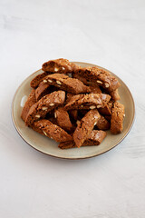 Homemade Italian Cantuccini with Almond and Coffee on a Plate on a gray surface, side view. Crispy Almond and Coffee Cookies.