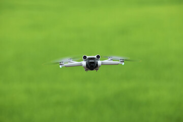 Flying drone quadcopter with a camera on green background.