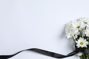 Beautiful chrysanthemum flowers and black ribbon on white background, top view with space for text....