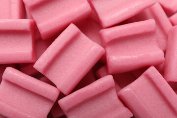 Tasty pink chewing gums as background, top view