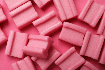 Tasty chewing gums on pink background, flat lay