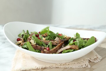 Delicious salad with beef tongue, arugula and seeds on table, closeup