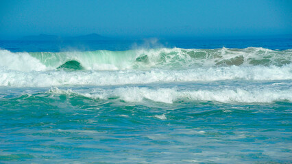  powerful cross ocean wave breaking during the day on the beach