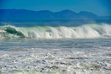  powerful cross ocean wave breaking during the day on the beach