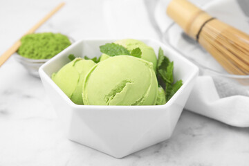 Tasty matcha ice cream in bowl on white table, closeup