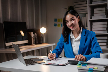 Cheerful young businesswoman sitting at her workplace