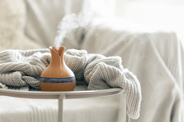Aroma composition with a modern aroma oil diffuser with a knitted element.