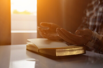 young man was praying to God in front of Bible with faith and power of faith in God. Bible study concept to understand and pray to God with faith in teachings of the Bible studied. Copy Space - obrazy, fototapety, plakaty