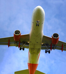A plane from the side approaching for landing, against the background of clouds. Airplane close-up