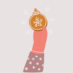 Vector illustration of hand holding a gingerbread cookie. Christmas ball shape.