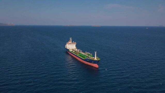 Oil chemical tanker ship holding her position at sea anchorage, aerial wide shot