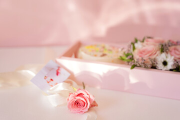 Cake with blooming roses in a pink gift box.