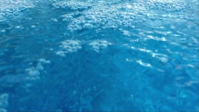 Captivating video capturing water bubbles from a poolside waterfall