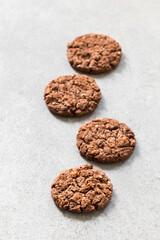 Vegan dessert. Chocolate cookies with oatmeal, chocolate chips and hazelnuts. Light grey background