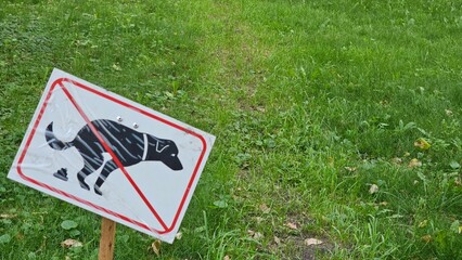 Prohibited to let an animal pets defecating shit in the garden area at public park. Sign and symbol for animal object photo, close-up