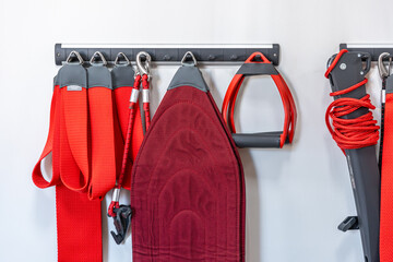 Red cord slings for therapeutic exercises and neuromuscular activation.