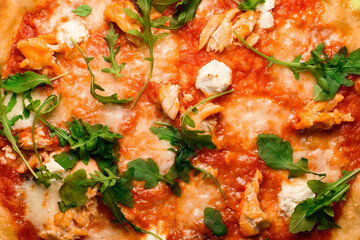 Obraz na płótnie Canvas Appetizing wallpaper with Italian pizza with tomato sauce, arugula, mozarella cheese and smoked chicken pieces