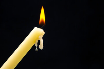 Lighting a candle with a wooden match on a dark background. Burning candle fire