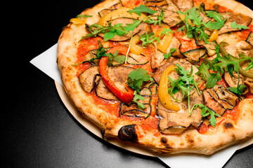 Delicious and colourful healthy vegetables pizza served on wooden board on black background