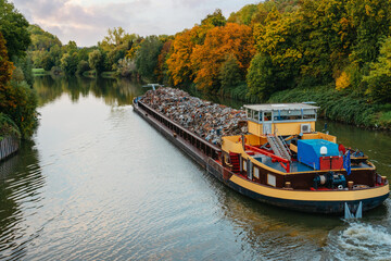Transportation industry. Ship barge transports scrap metal and sand with gravel. Barge loaded with...
