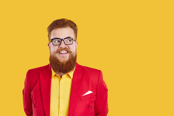 Portrait of redhead bearded chubby smiling man in glasses and funky outfit yellow shirt and red...