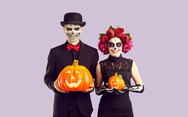 Happy couple dressed in skeleton costumes for Halloween or Day of the Dead. Man and woman with...