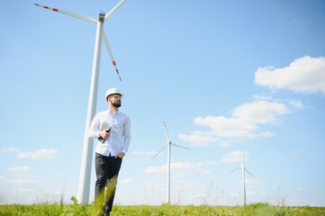 Engineer in field checking on turbine production