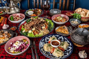 Traditional Uzbek oriental cuisine. Uzbek family table from different dishes for the New Year holiday. The background image is a top view. - obrazy, fototapety, plakaty