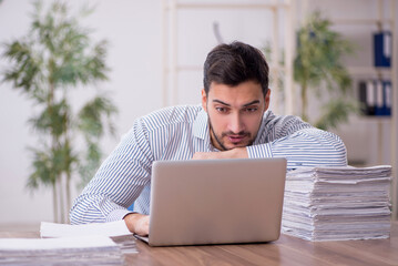 Young male employee and too much work in the office