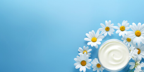 Fototapeta na wymiar Opened Container with Cream Surrounded by Chamomile Flowers on Blue Background, Natural Cosmetic