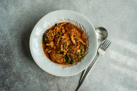 Georgian Gupta dish of meatballs with rice stewed in tomato sauce with cabbage, carrot and onion, served with chopped coria