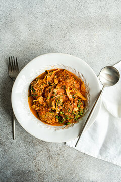 Georgian Gupta dish of meatballs with rice stewed in tomato sauce with cabbage, carrot and onion, served with chopped coria