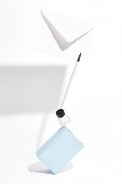Balancing composition with a blue tea box, a white envelope and a writing pen