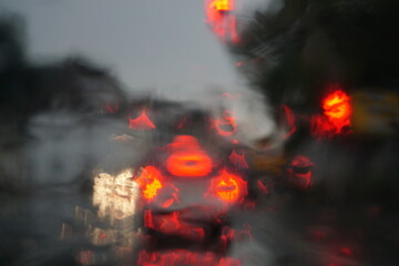 Abstraktes Motiv mit fahrendem Auto auf Straße mit rot-gelb-weißen Lichtern auf nasser Straße...