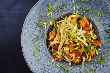 Traditional fried tagliatelle con galletti with mushrooms and pistachios served as top view on a...