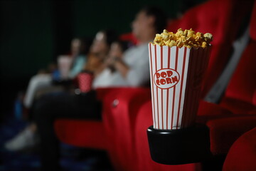 pop corn and happy people in cinema enjoying a movie, popcorns and beverages over the weekend.