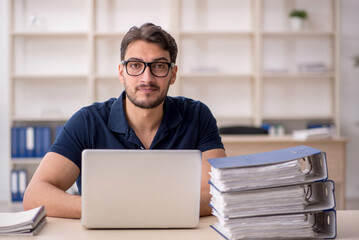 Young male employee sitting at workplace