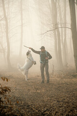 happy dog and owner in foggy forest
