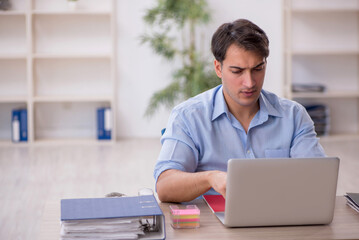 Fototapeta premium Young male employee working in the office