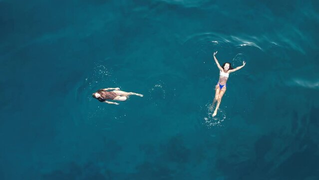 Aerial view of amazing girls swimming together.